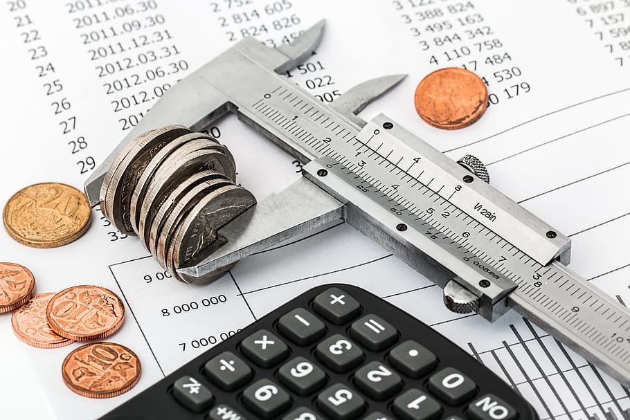 Image of a calculator, some loose change, and a ruler